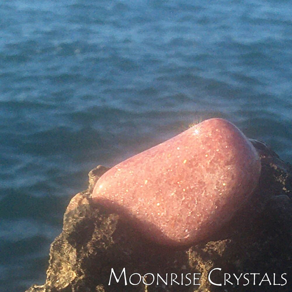 Pink Aventurine over a rock in the beach