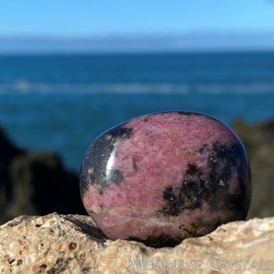 Close up of Rhodonite with the ocean in the background
