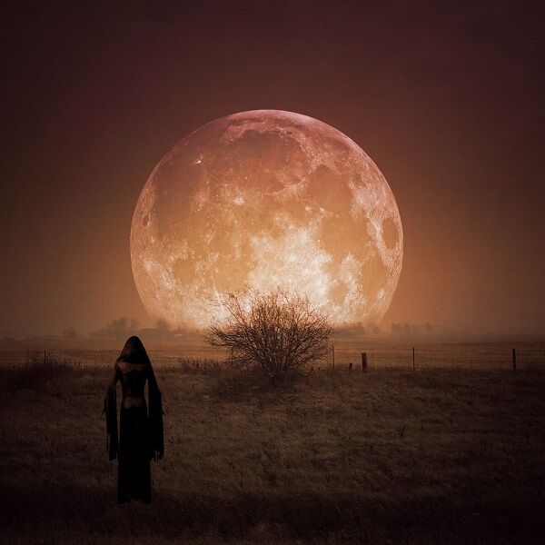 Huge orange Moon dominates the sky, a woman in a dress in the foreground