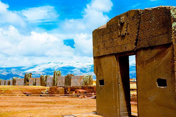 Tiwanaku pillars, the ruins are orange-brown but there is a vivid blue sky in the background