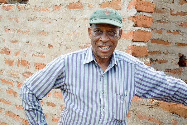 Photograph of Ndugu Jumanne Ngoma wearing a striped shirt and baseball hat