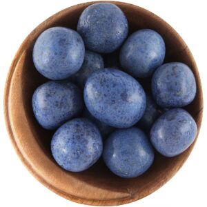Bowl of tumbled Dumortierite crystals. Round shapes, the stones are bright blue with darker blue spots.