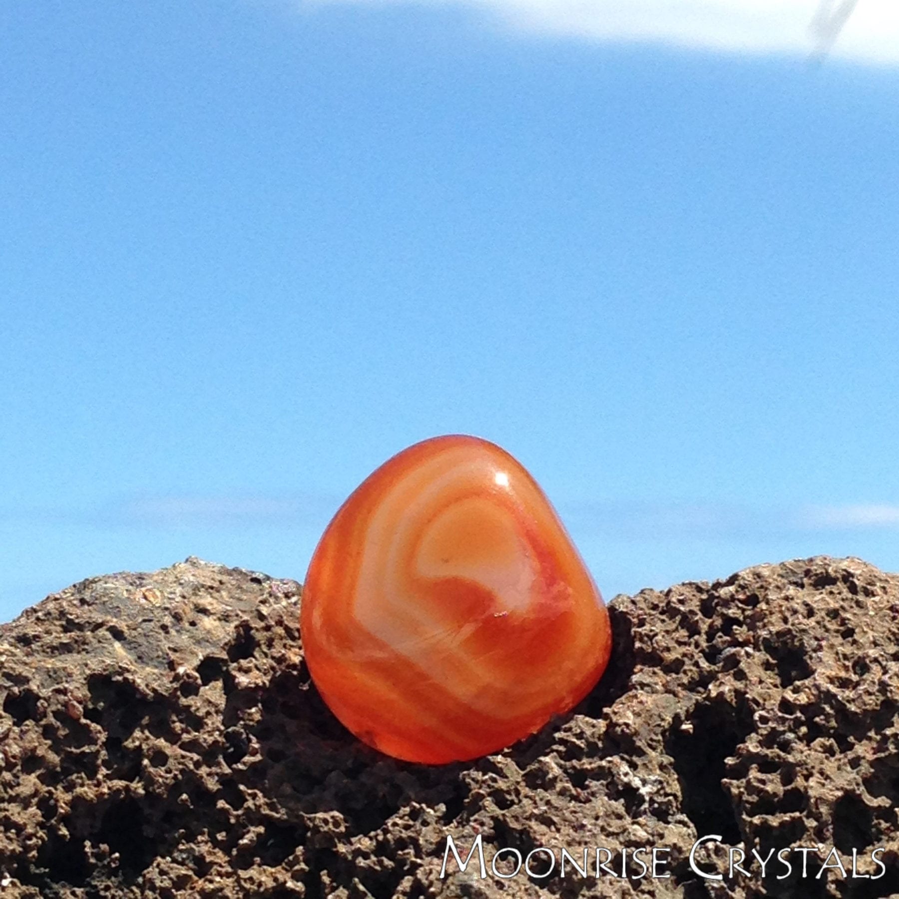 Banded Carnelian on lava rock with blue sky