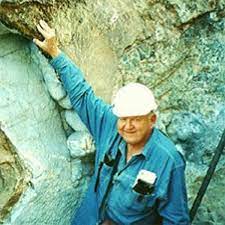 Photograph of George Swanson smiling and wearing a hardhat at the mine