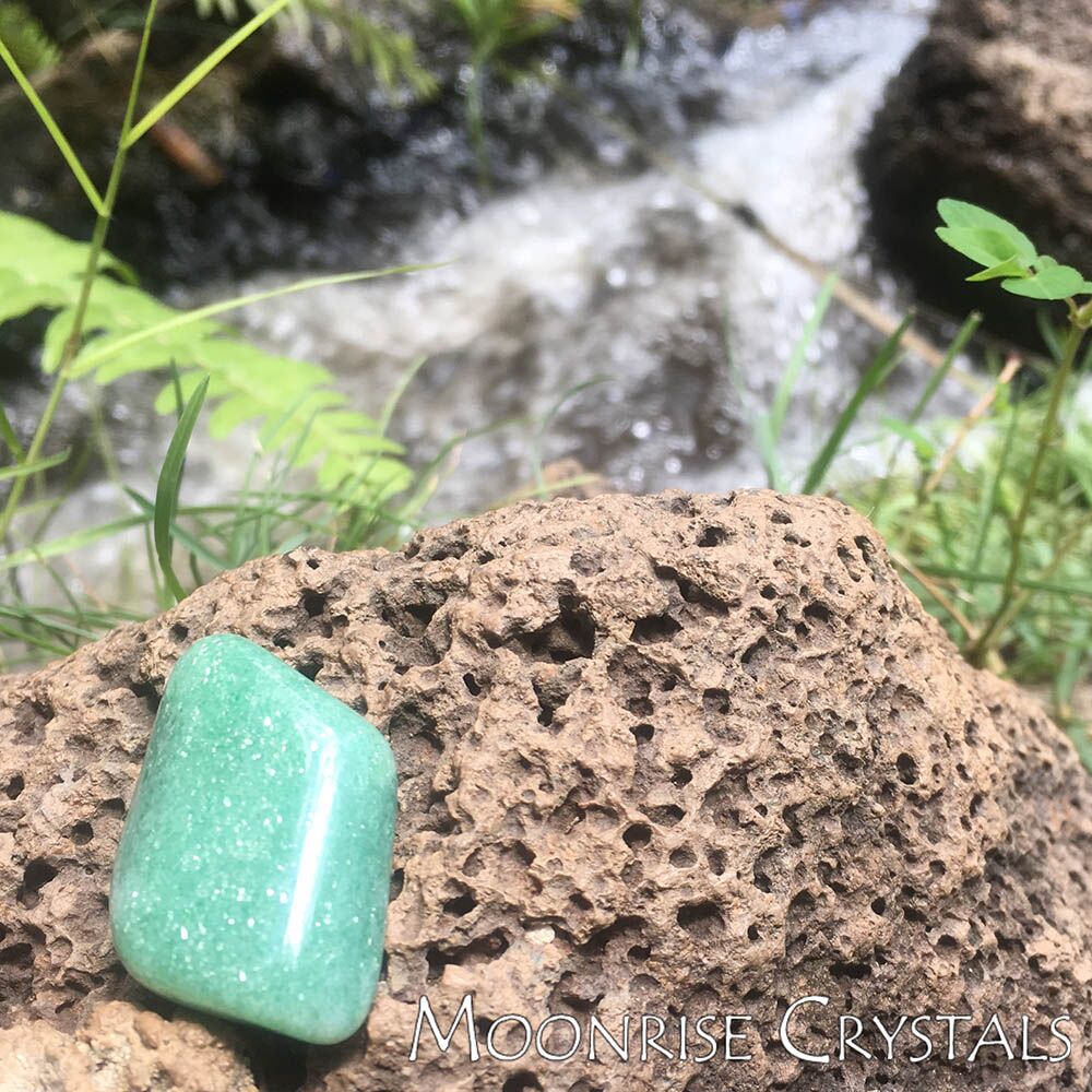 Green Aventurine over a river rock
