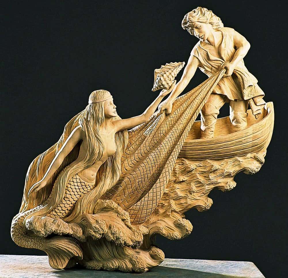 Jurate A wooden sculpture of a man in a boat and a mermaid in the water